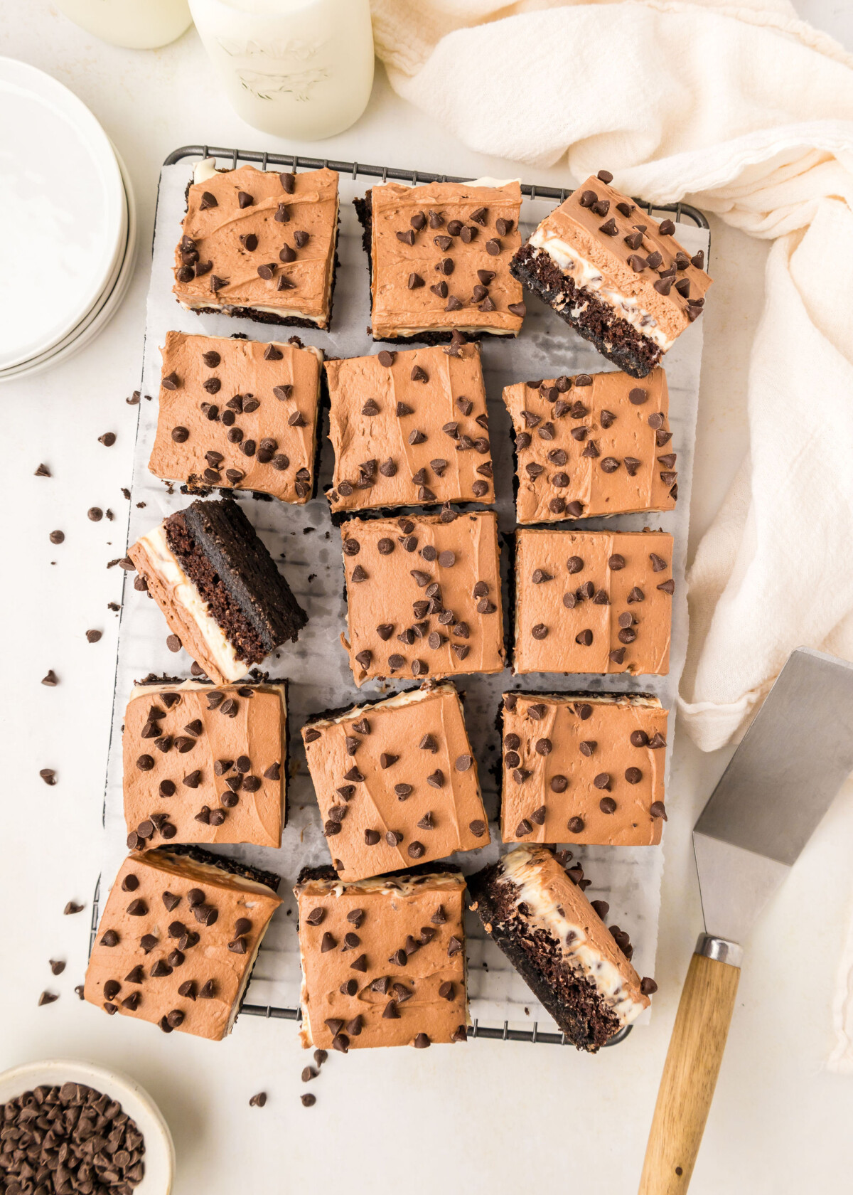 A tray of chocolate cake bars cut into squares on a cooling rack.