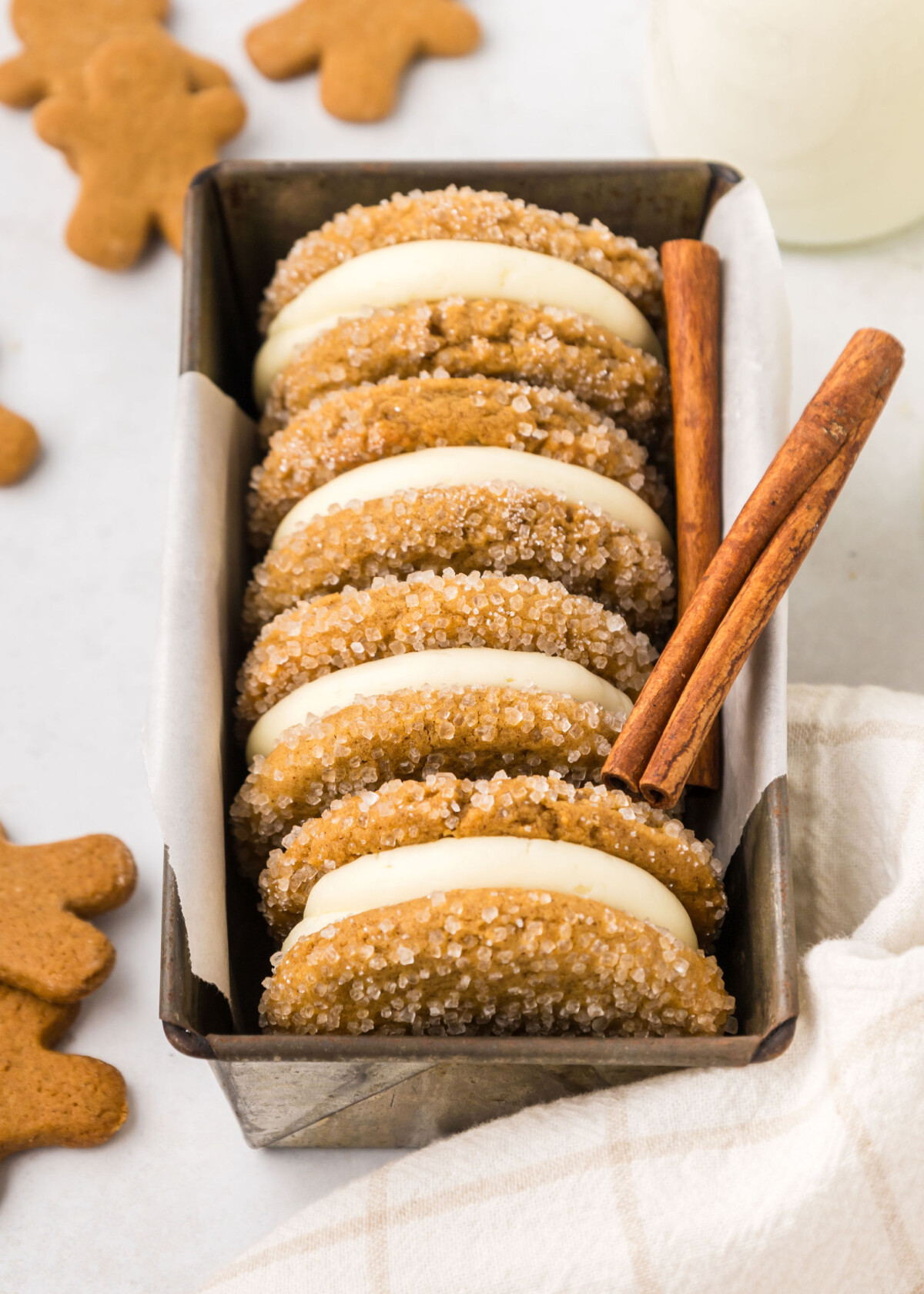 Four gingerbread sandwich cookies in a tin.