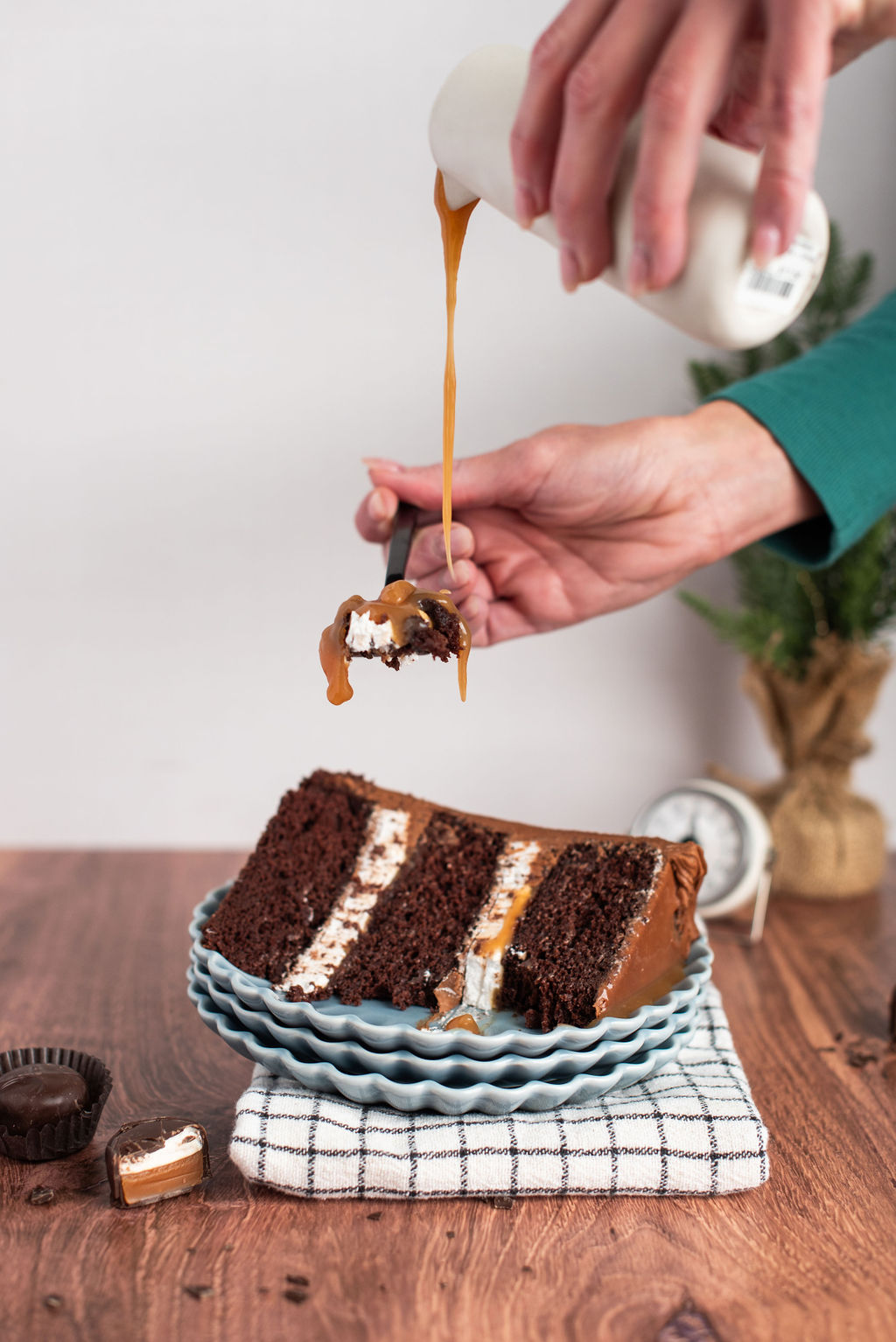 A woman pouring caramel onto a bite of cake.