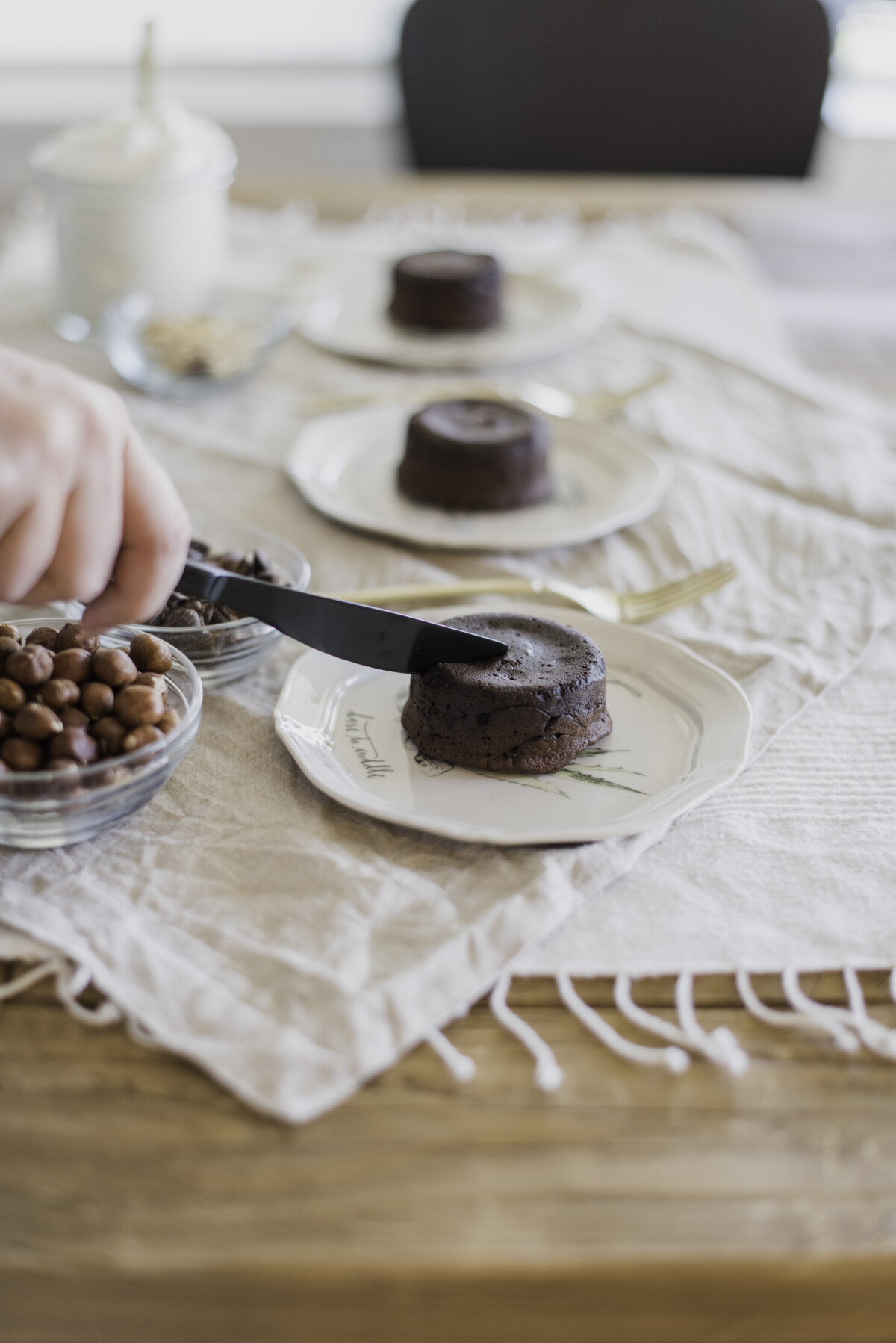 A plate of chocolate lava cakes with molten centers, garnished with fresh raspberries and powdered sugar.