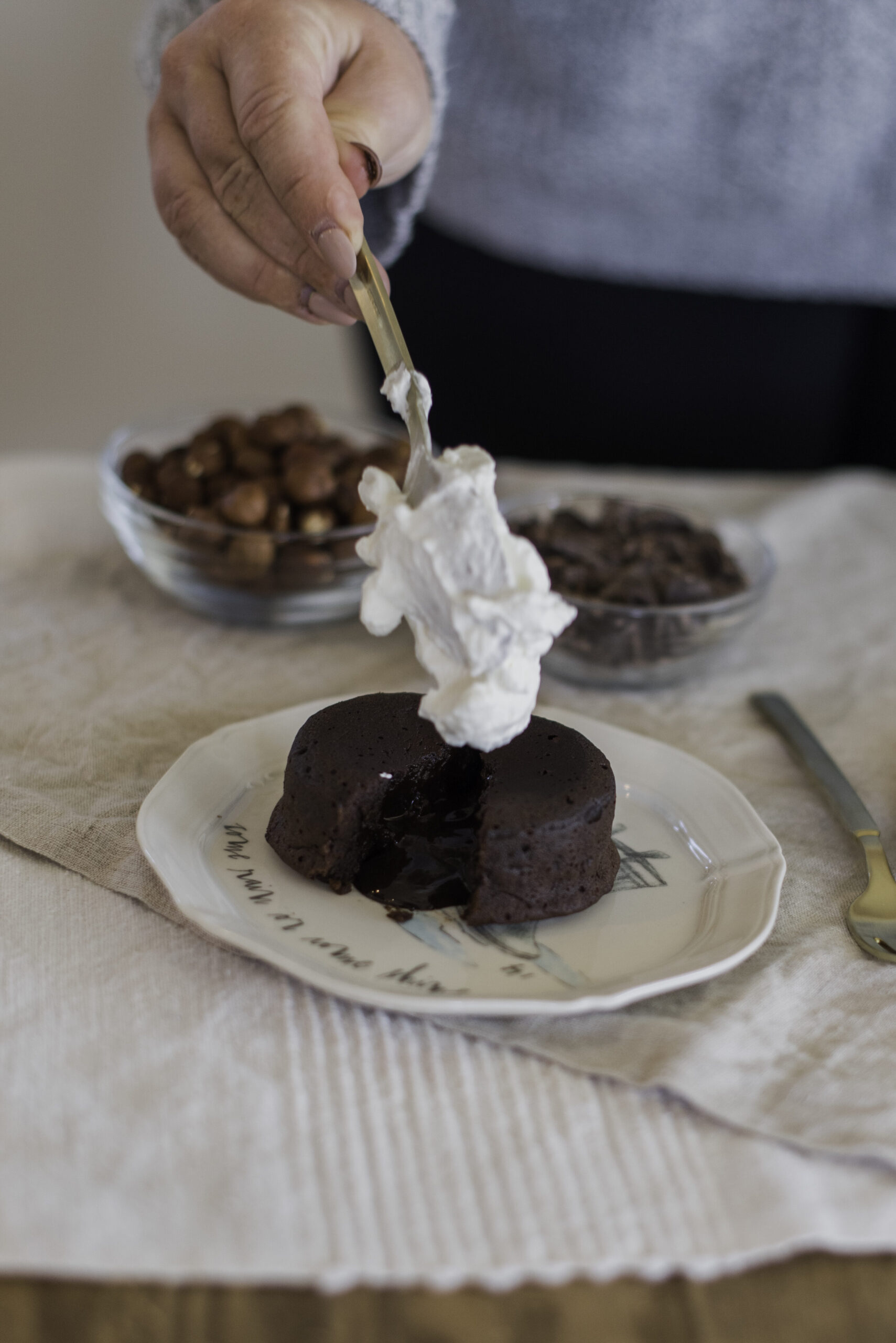 A plate of chocolate lava cakes with molten centers, garnished with fresh raspberries and powdered sugar.