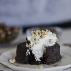 Chocolate lava cake on a plate with chocolate spilling out of the center.