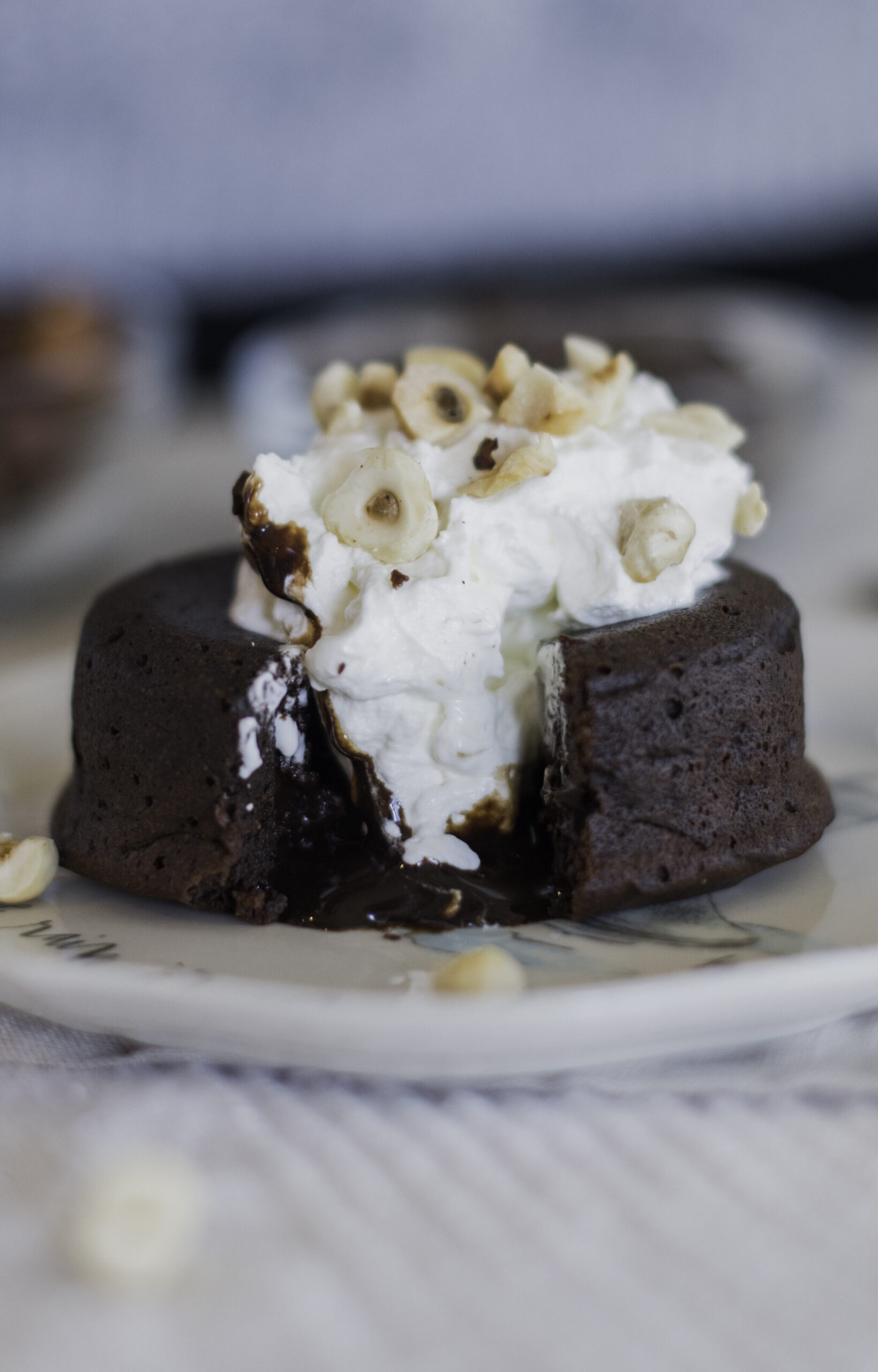 Chocolate lava cake on a plate with chocolate spilling out of the center.