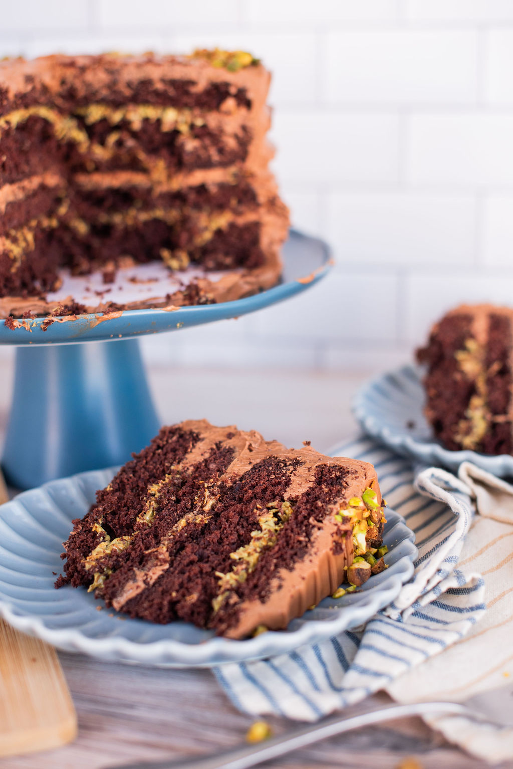 A slice of Dubai Chocolate Bar inspired cake on a blue plate with a towel.