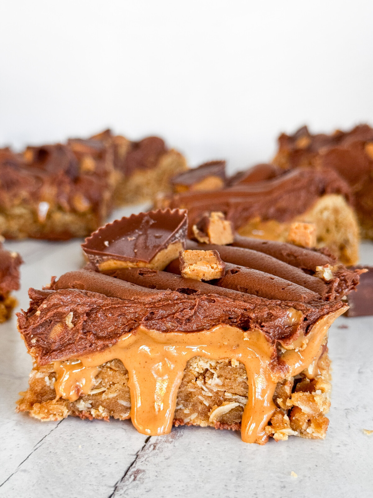 A peanut butter blondie bar with peanut butter dripping and chocolate buttercream.
