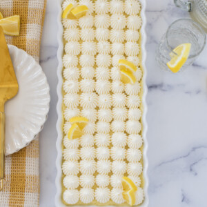 Lemon tart in a pan with lemons on top.