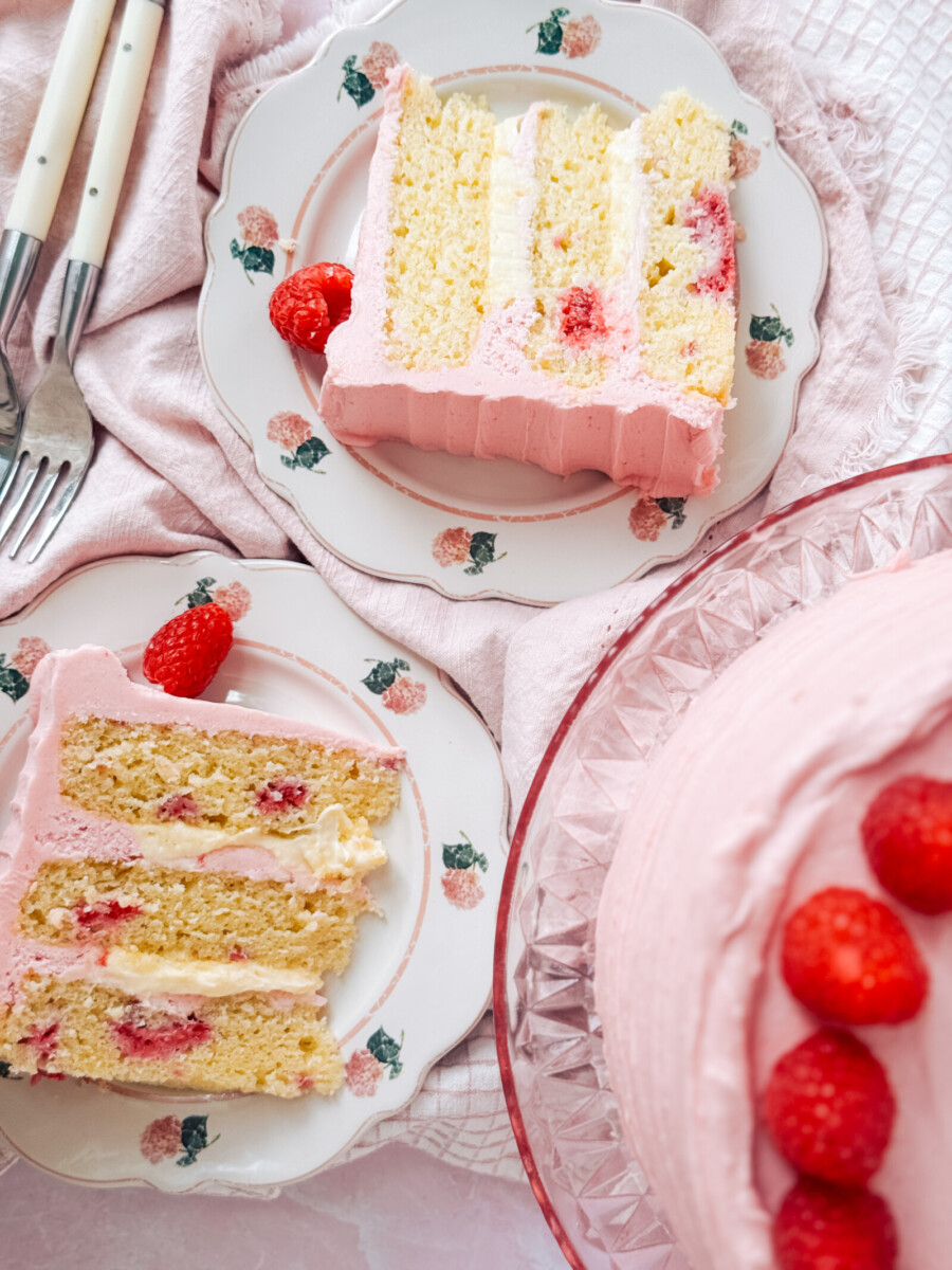 Two slices of cake on plates with pink napkins and forks.