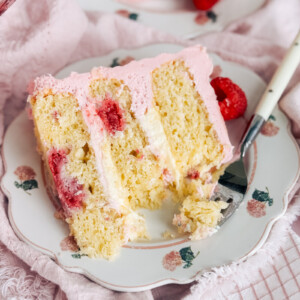 A slice of raspberry cheese danish cake on a floral plate with a fork.